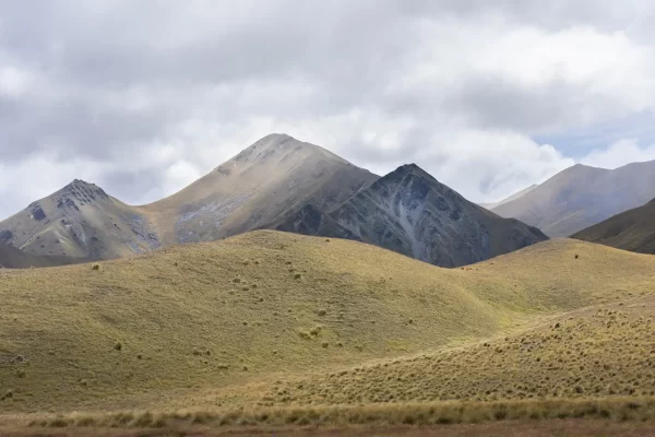 Lindis Pass mountains covered in yellow tussock with an overcast sky