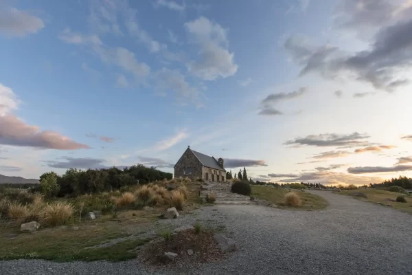 Sunset over a small stone church in Teakpo surrounded by tussocks and pine trees