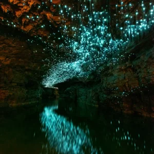 Underground cave river in New Zealand with thousands of glowworms in the ceiling reflecting in the river