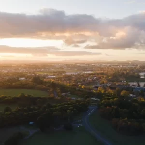 Aerial view of Ballarat West at Sunset with golden light and lake Wendouree and mountains in the distance