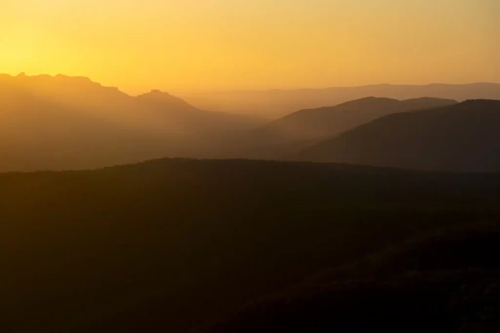 Sunset at Reeds lookout with yellow golden light towards mountain tops