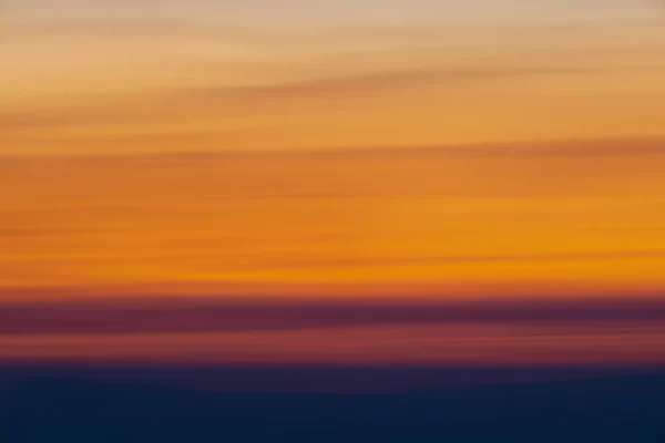 ICM photo of sunrise with blacks, oranges and yellow blurs