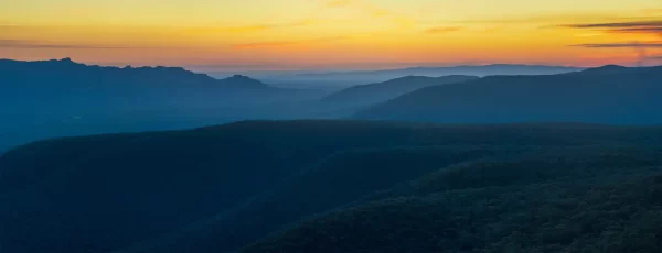 Panoramic view from Reeds Lookout at sunset with gum tree lined mountain ridges