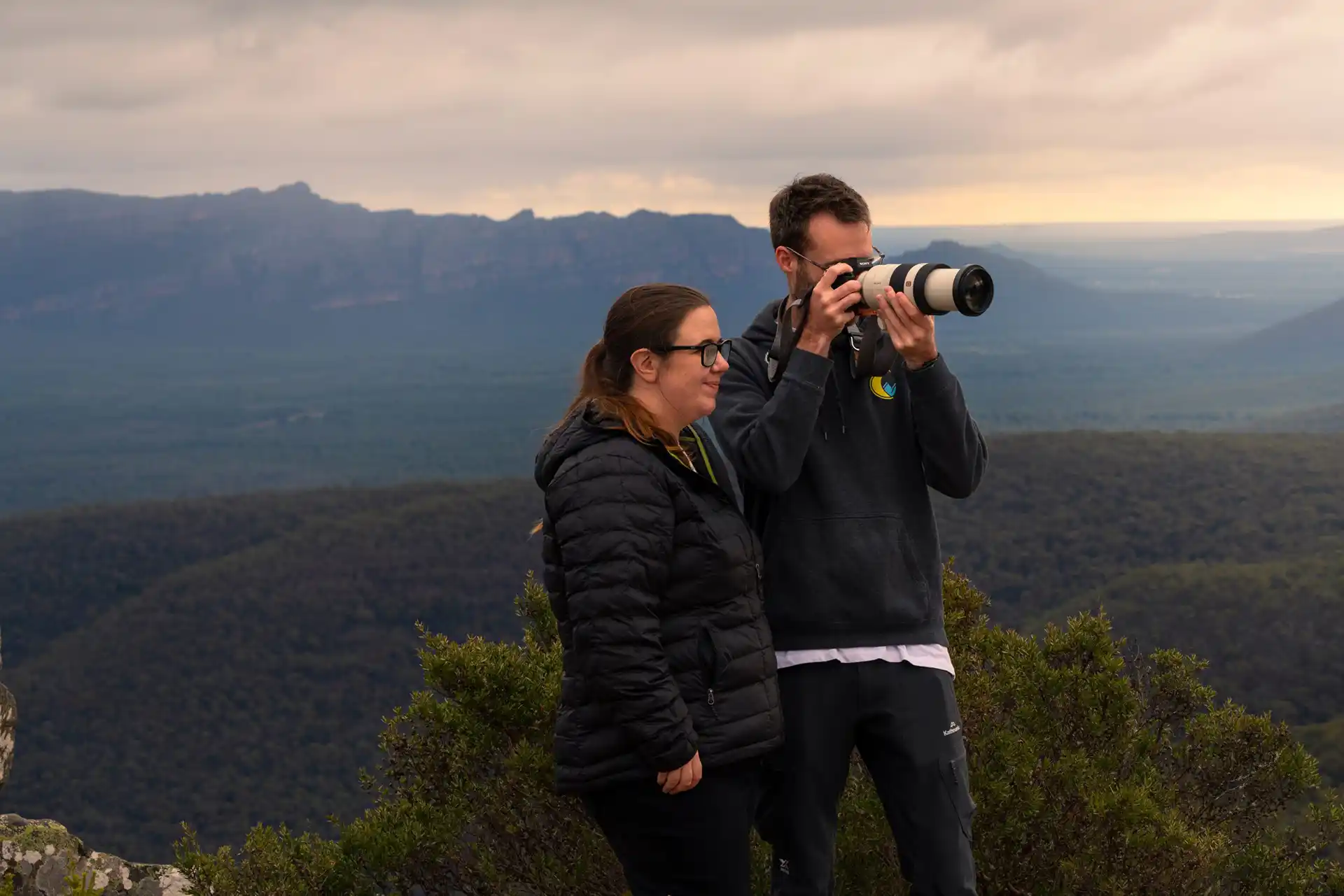 Emma and Andy from the Click Collective taking photos on a mountain in the Grampians