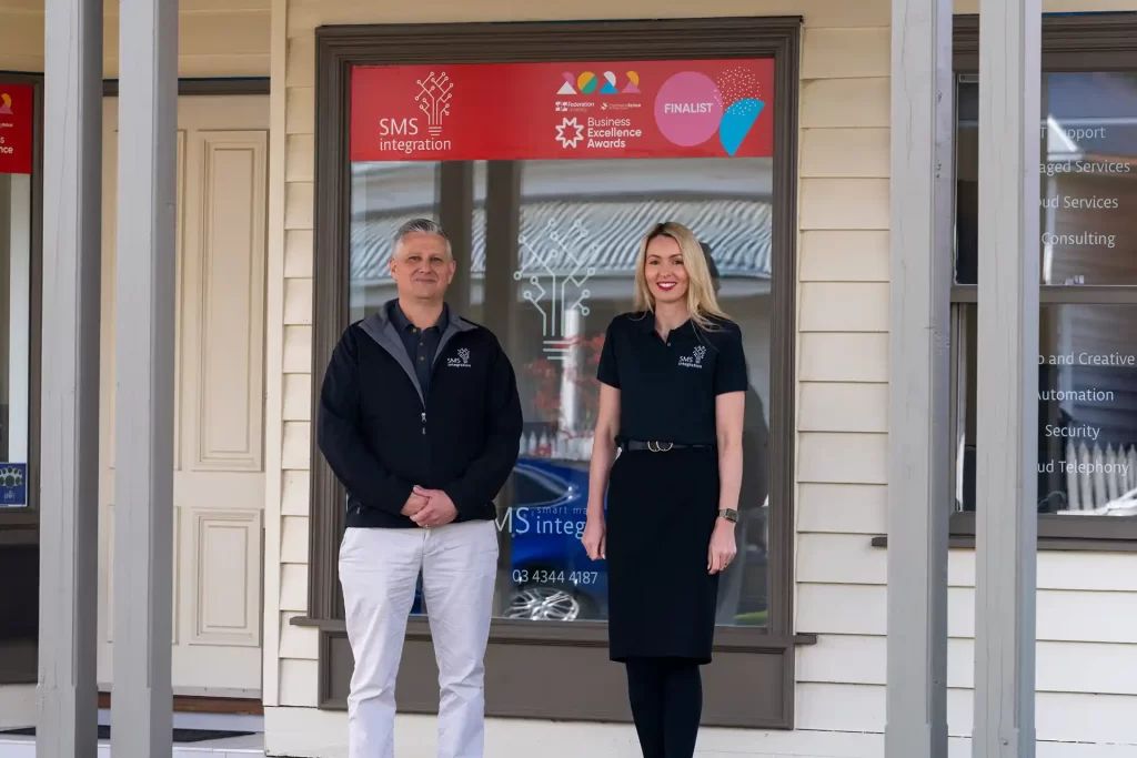 Corporate photo of business owners standing in front of their shop front