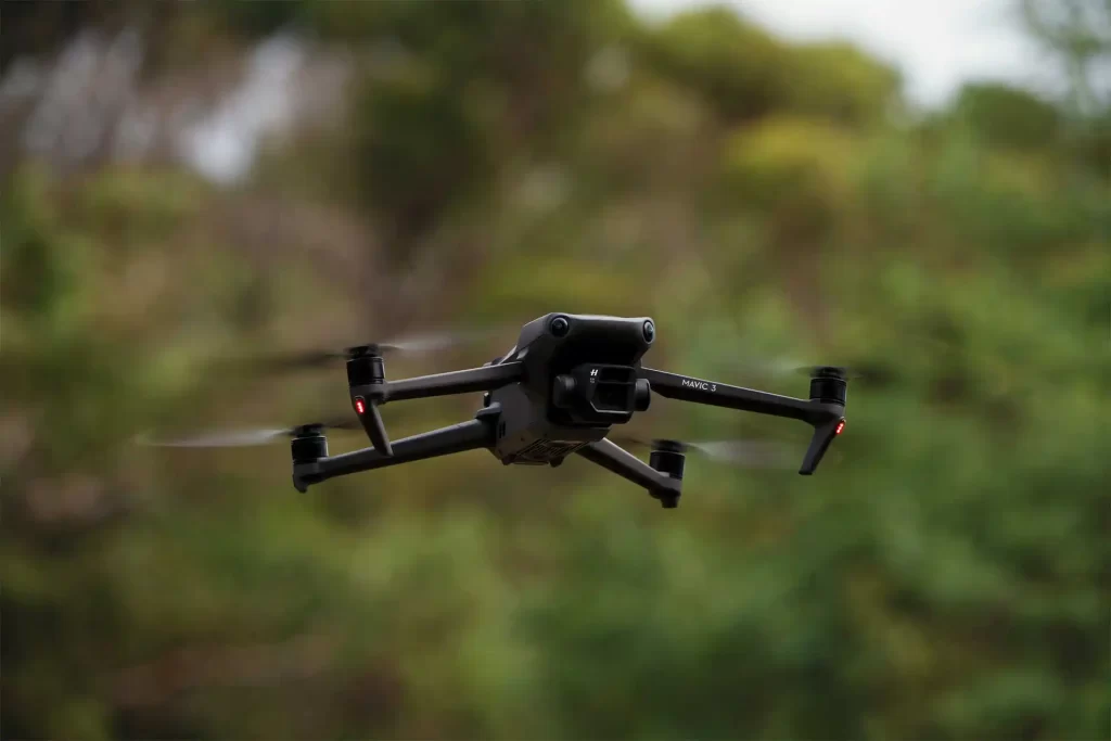 Drone in flight in front of a forest