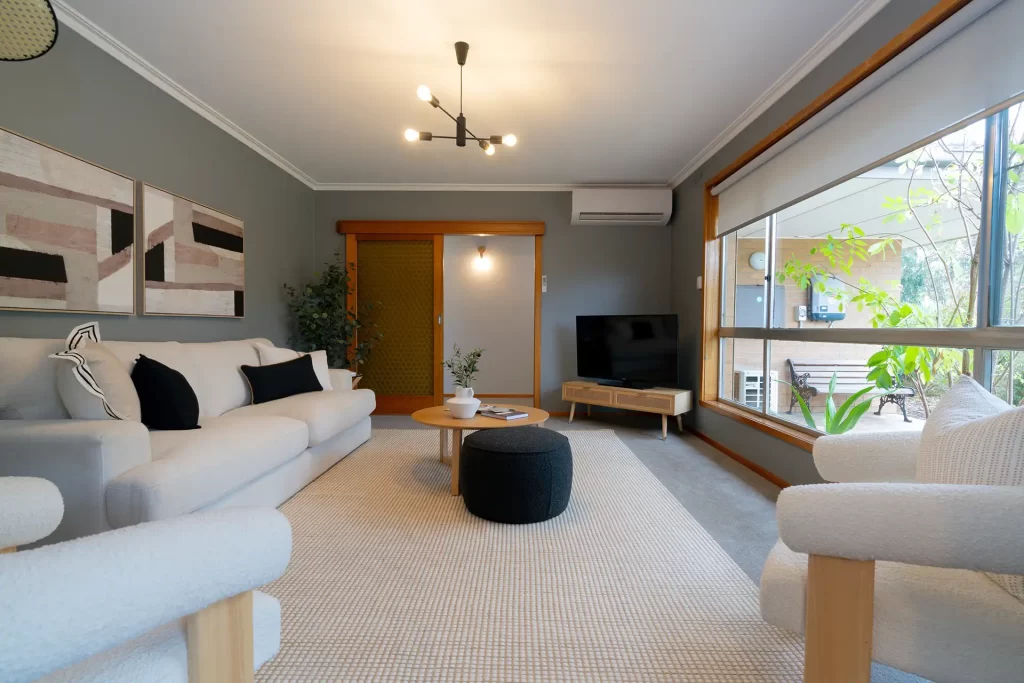 Real estate image of an open lounge room furnished with light coloured furniture